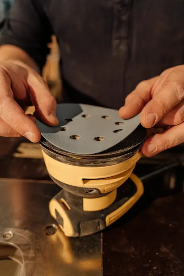 Båtmekaniker setter slipepapir på maskin før båtservice i Østfold